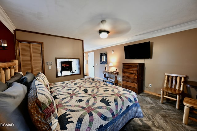 bedroom with dark parquet floors, a closet, ornamental molding, and ceiling fan