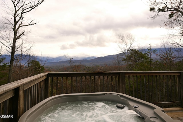 wooden deck with a mountain view and a hot tub