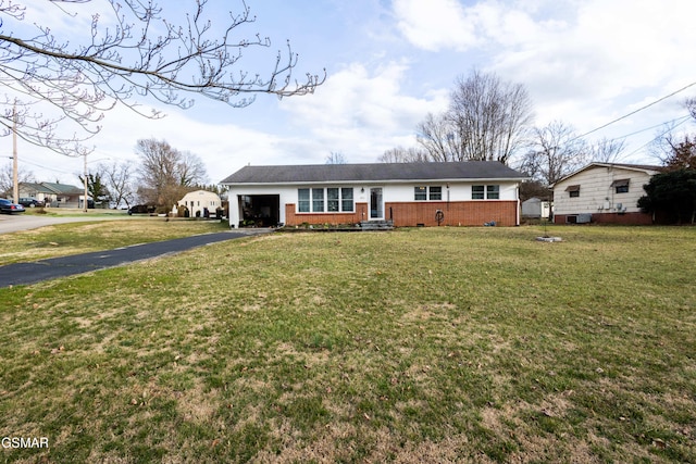 ranch-style home featuring brick siding, an attached garage, a front yard, crawl space, and driveway