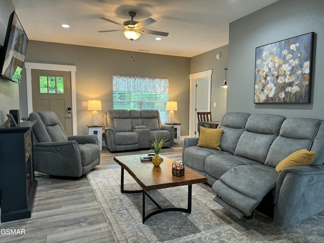 living room with light wood-style flooring, a ceiling fan, and recessed lighting