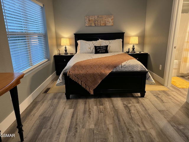 bedroom featuring baseboards and light wood finished floors