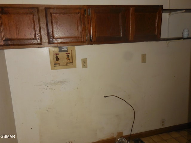 clothes washing area with cabinets and hookup for a washing machine