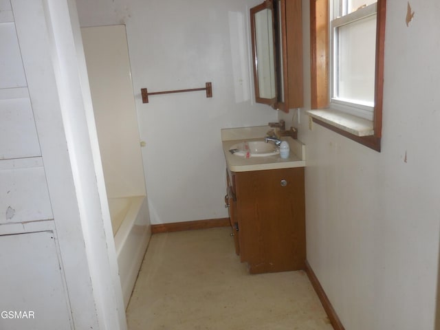 bathroom with a tub and vanity