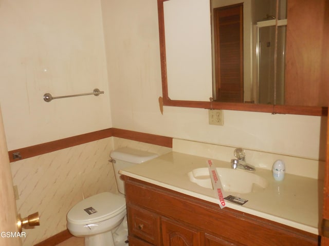 bathroom with vanity, toilet, and tile walls