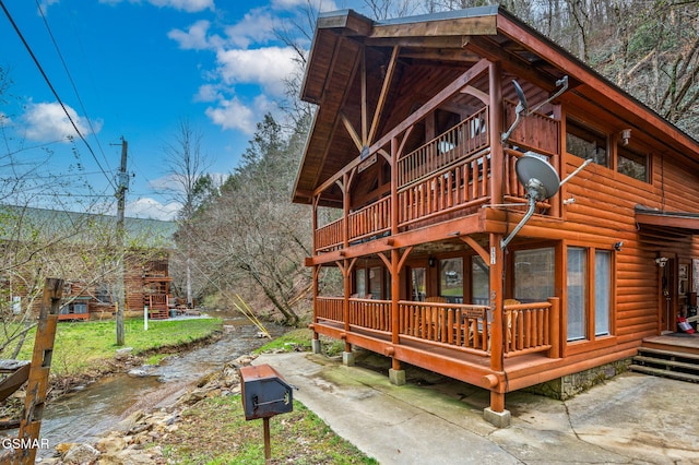 exterior space with faux log siding and a deck with water view