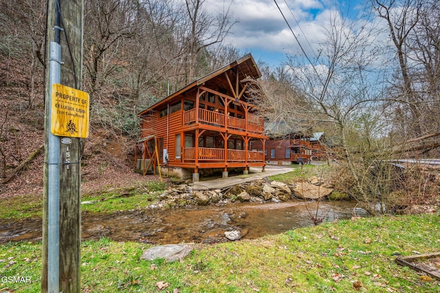 back of property featuring faux log siding and a deck