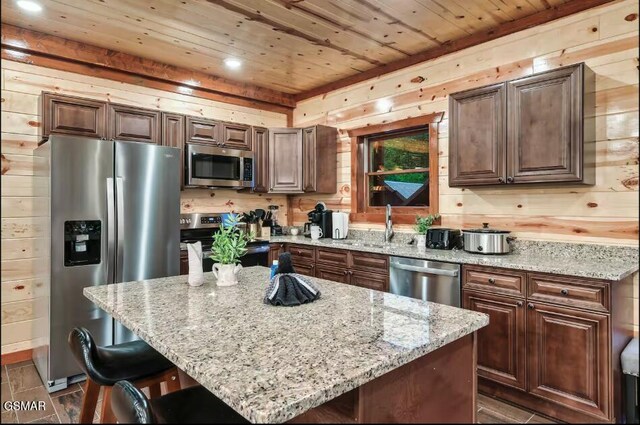 2623 Rogers Way, Sevierville, TN 37876 - kitchen featuring wood ceiling, light stone counters, wood walls, and stainless steel appliances