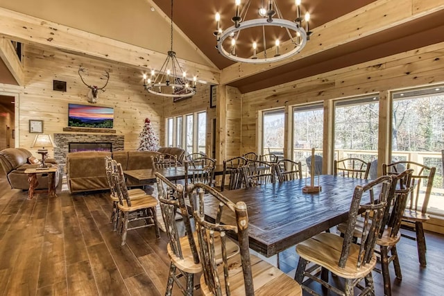 604 Cherokee Orchard Rd, Gatlinburg, TN 37738 - dining space featuring a chandelier, wooden walls, dark wood-style flooring, high vaulted ceiling, and a fireplace