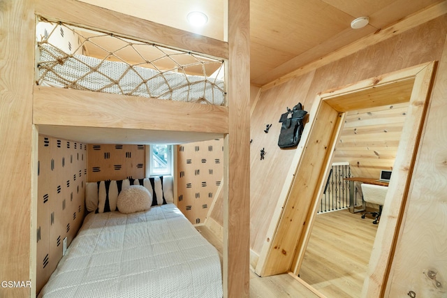 bedroom featuring wood walls and wood finished floors