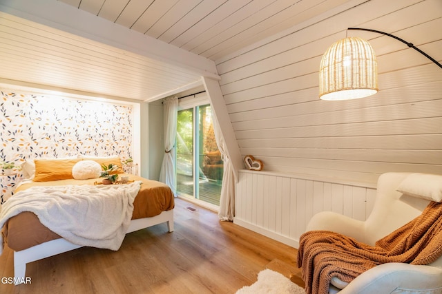 bedroom with wood ceiling, radiator heating unit, wood finished floors, access to exterior, and beam ceiling