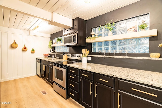 kitchen with visible vents, light wood-style flooring, stainless steel appliances, open shelves, and a sink