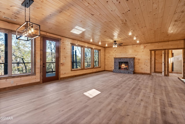 unfurnished living room with wood walls, hardwood / wood-style floors, wood ceiling, and ceiling fan with notable chandelier