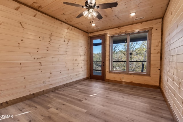 empty room with wood walls, ceiling fan, wooden ceiling, and light wood-type flooring