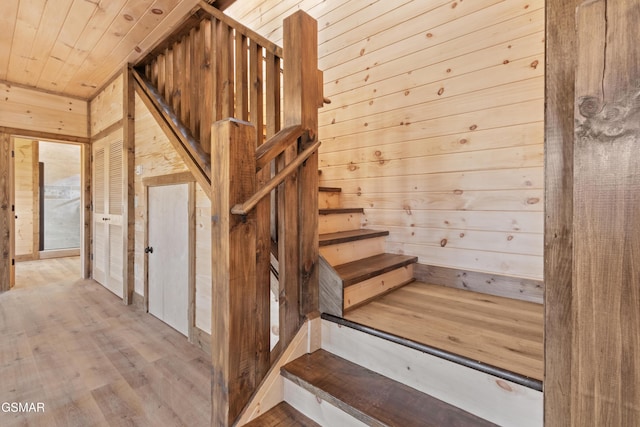 stairway with hardwood / wood-style flooring, wood walls, and wood ceiling