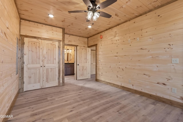 unfurnished bedroom featuring wooden walls, ceiling fan, ensuite bathroom, and wooden ceiling