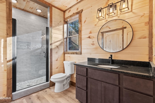 bathroom featuring walk in shower, wood walls, hardwood / wood-style floors, toilet, and vanity