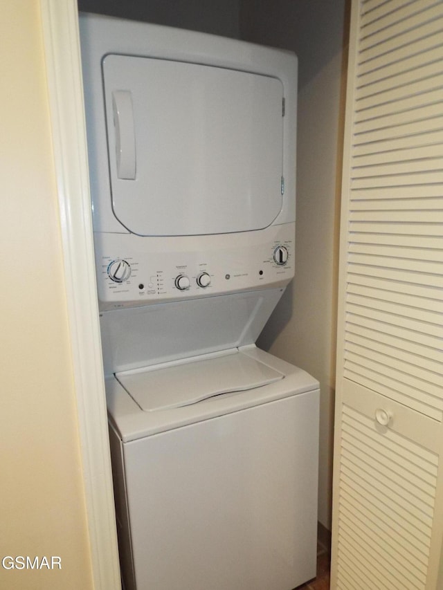 clothes washing area with stacked washer / dryer and laundry area