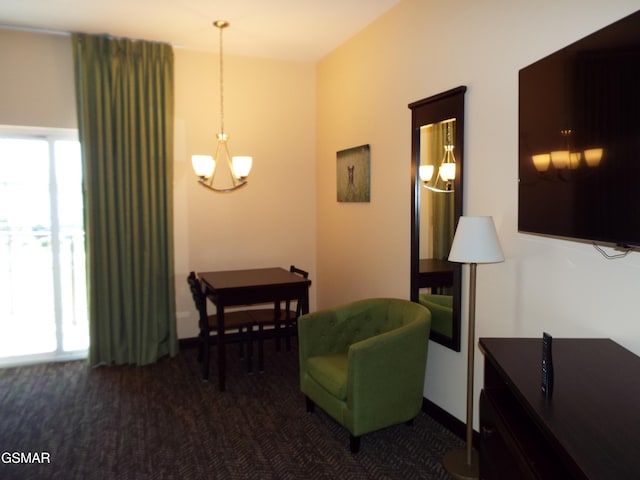 sitting room with dark carpet, a notable chandelier, and baseboards