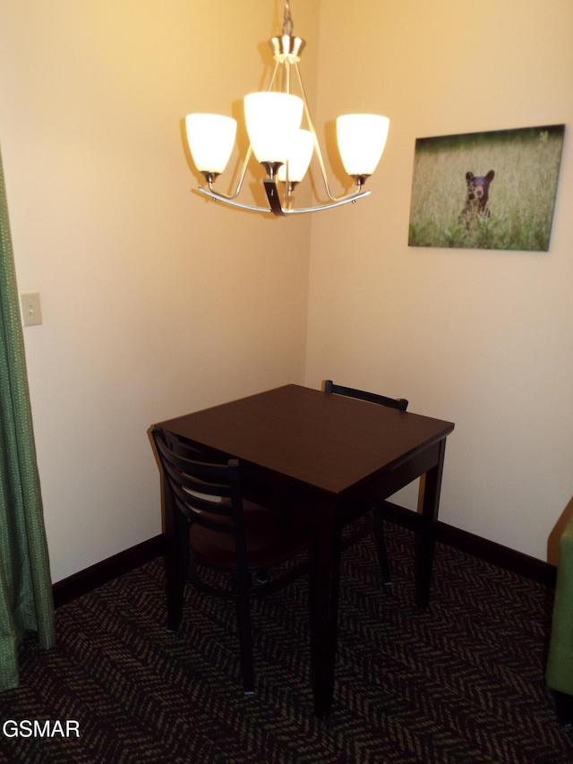 dining area with baseboards and a chandelier