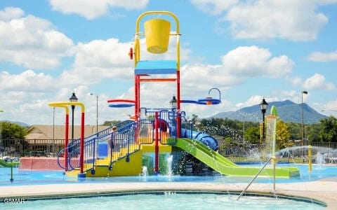 community playground featuring a mountain view and fence