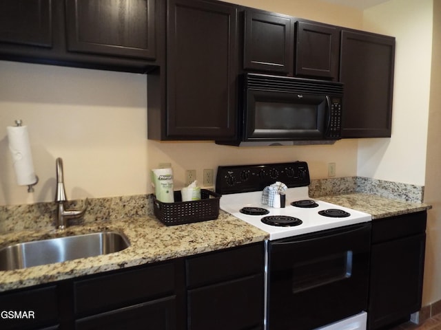 kitchen with a sink, black microwave, electric stove, and light stone countertops