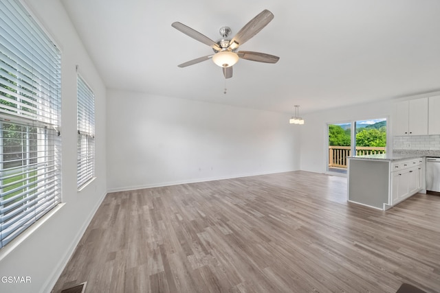 3206 Bativa Garden Ct, Sevierville, TN 37876 - unfurnished living room with light wood finished floors, a ceiling fan, and baseboards