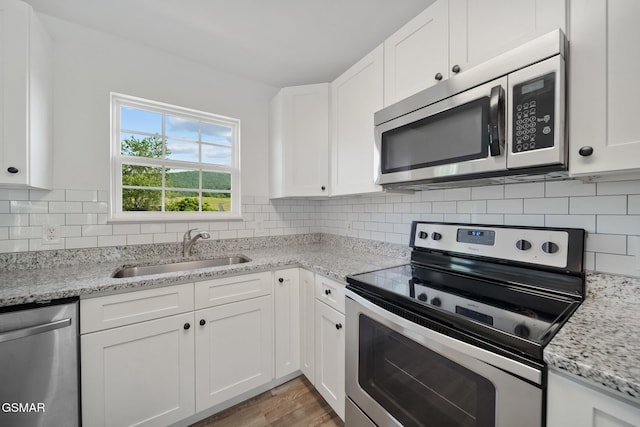3206 Bativa Garden Ct, Sevierville, TN 37876 - kitchen with stainless steel appliances, a sink, white cabinets, and tasteful backsplash