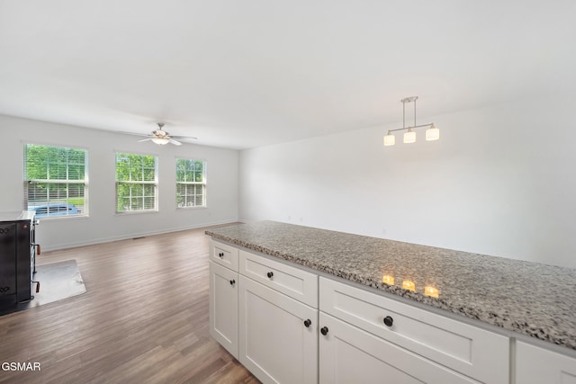 3206 Bativa Garden Ct, Sevierville, TN 37876 - kitchen with ceiling fan, light wood-style floors, white cabinets, light stone countertops, and pendant lighting