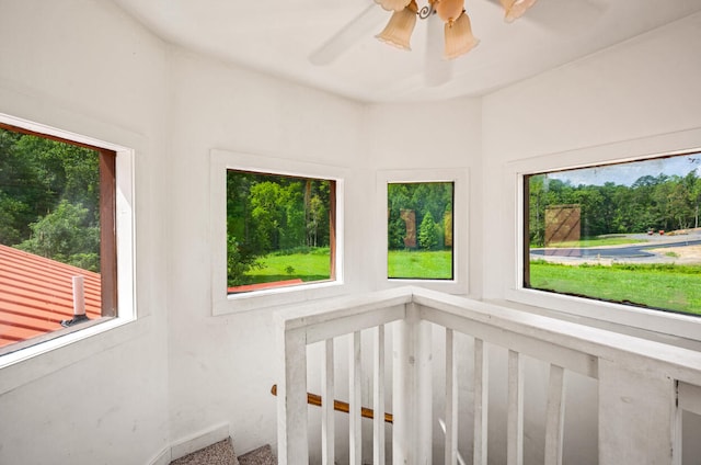 unfurnished sunroom with ceiling fan