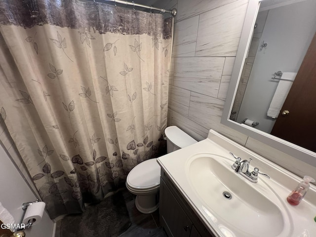 bathroom featuring vanity, a shower with shower curtain, tile walls, and toilet