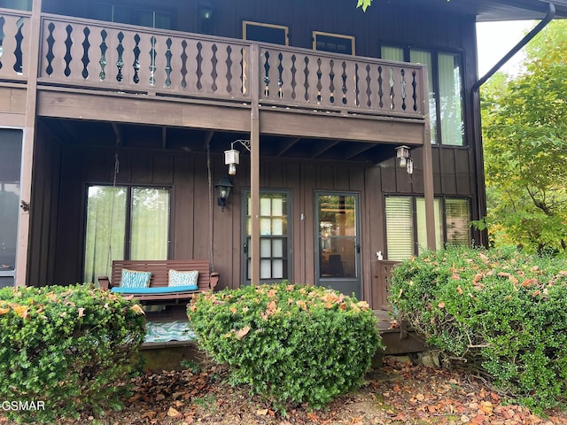 view of exterior entry featuring a balcony