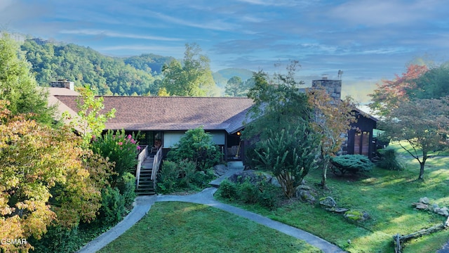 view of front facade featuring a mountain view and a front yard