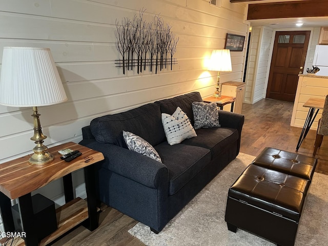 living room with hardwood / wood-style flooring and wooden walls