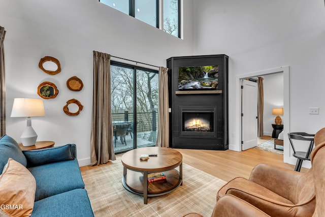 living room featuring a high ceiling and light hardwood / wood-style floors