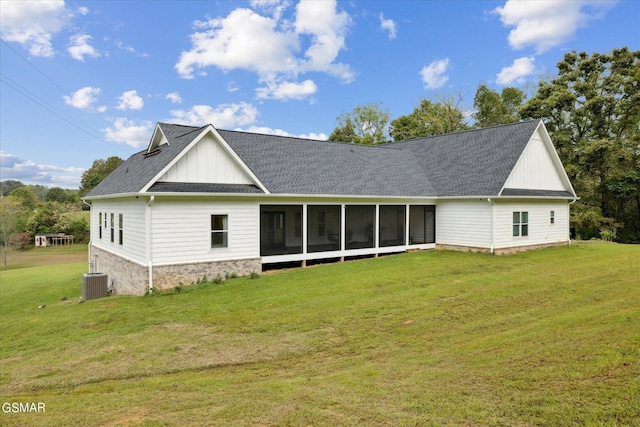 back of house with a sunroom, a lawn, and central AC