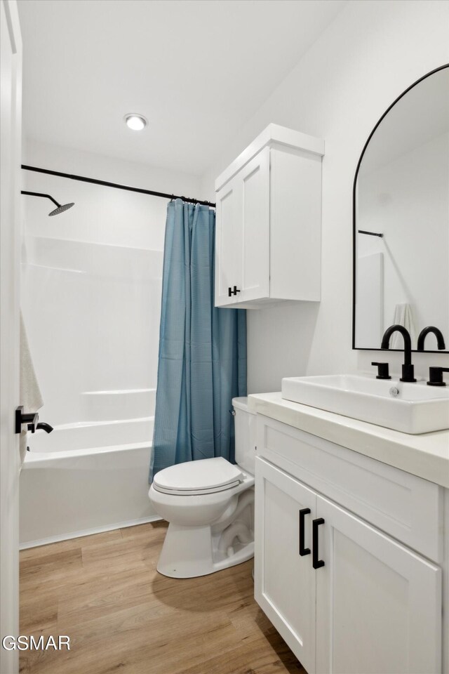 full bathroom featuring shower / tub combo, vanity, hardwood / wood-style flooring, and toilet