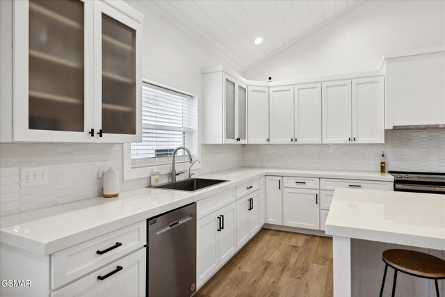 kitchen with white cabinets, sink, vaulted ceiling, light wood-type flooring, and stainless steel appliances