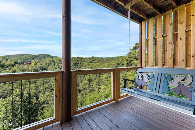 wooden terrace featuring a forest view