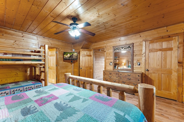 bedroom with wooden ceiling, light wood-style flooring, and wooden walls