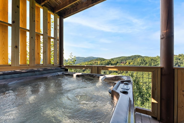 exterior space with a hot tub and a mountain view