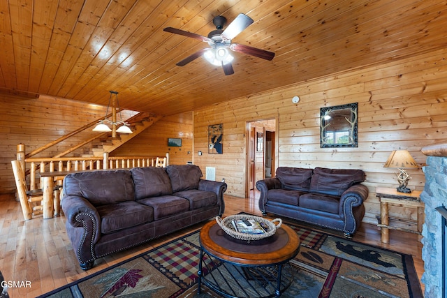 living room featuring a ceiling fan, wooden ceiling, wood walls, and wood finished floors