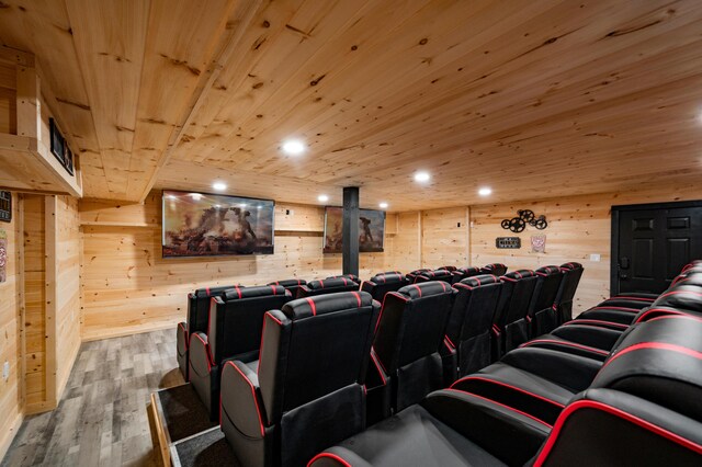 cinema room featuring wooden walls, wood ceiling, and hardwood / wood-style flooring