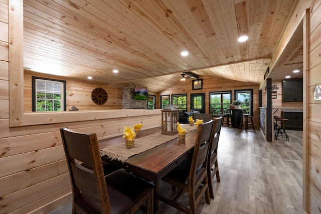 dining space featuring ceiling fan, wood walls, vaulted ceiling, wood ceiling, and hardwood / wood-style flooring