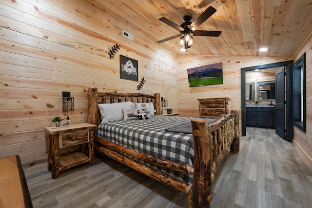 bedroom featuring ceiling fan, wood walls, wood ceiling, and vaulted ceiling