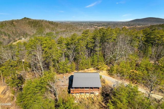 birds eye view of property featuring a mountain view and a view of trees