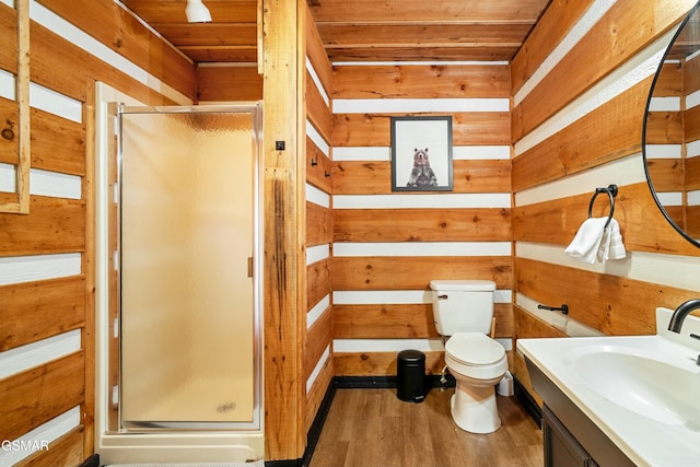 bathroom featuring toilet, a stall shower, wood walls, wood finished floors, and wooden ceiling