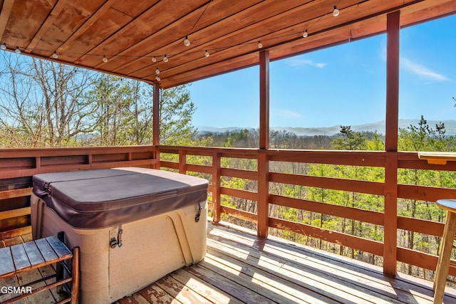 wooden deck featuring a mountain view and a hot tub