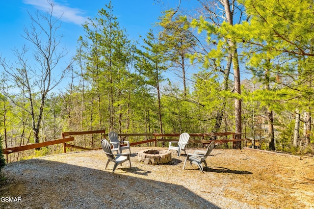 exterior space featuring a fire pit and a view of trees