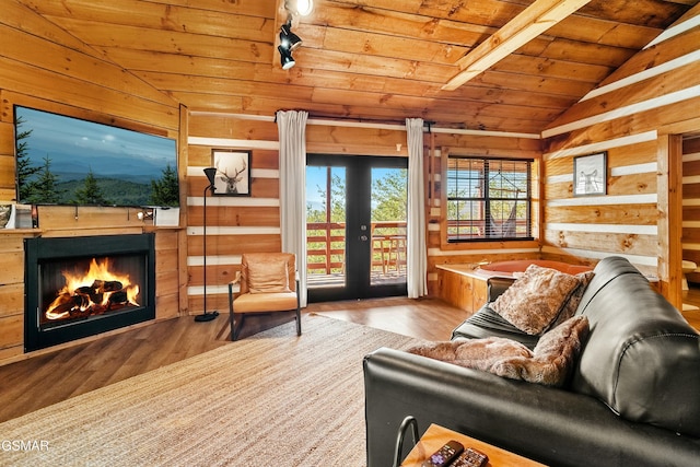 living area with lofted ceiling, wood ceiling, and wooden walls