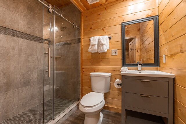 2837 Cedar Falls Way, Sevierville, TN 37862 - bathroom featuring a shower stall, toilet, vanity, and wood walls